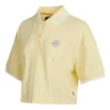 Camiseta polo curta com blocos de cor e logotipo em creme e amarelo