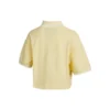 Camiseta polo curta com blocos de cor e logotipo em creme e amarelo